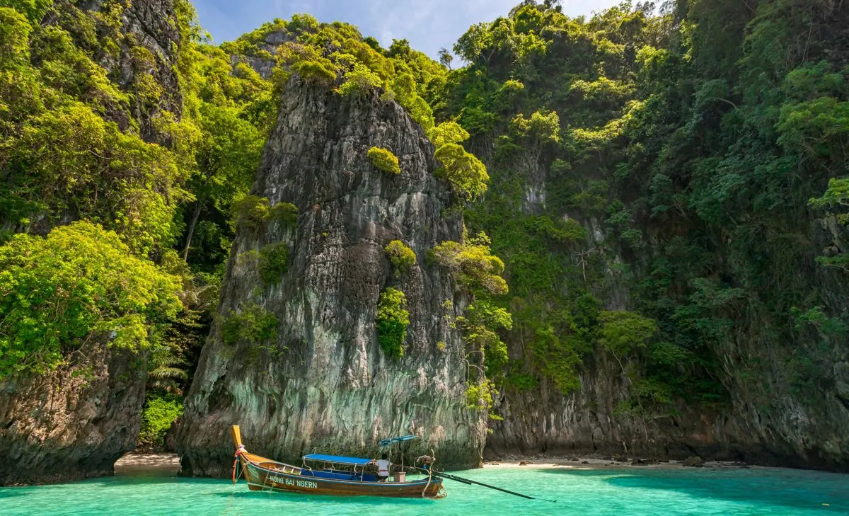 Long-tail boat in the clear water by the cliffs, Phi Phi