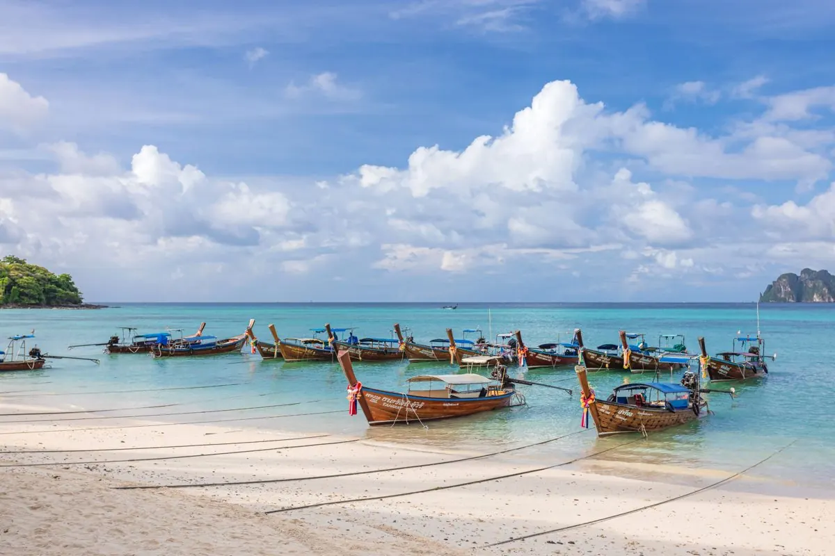 Long-tail boats waiting on the white sand